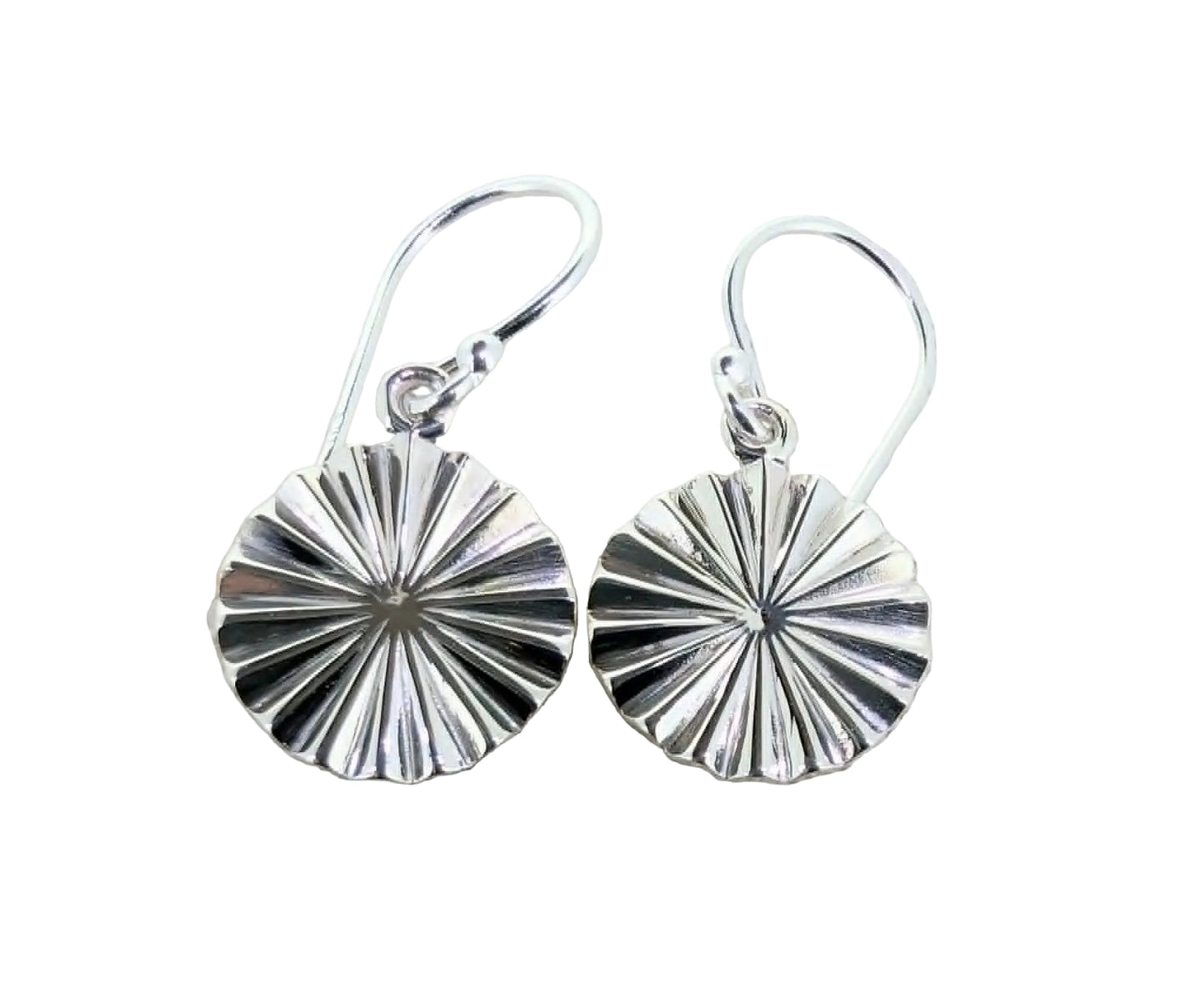 Pair of silver earrings on a textured beige fabric background