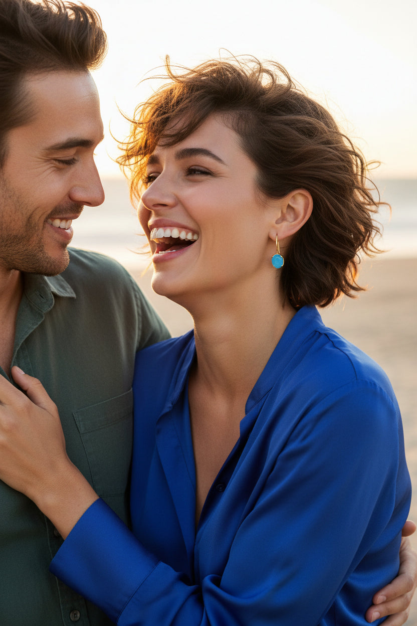 Gold-enhanced sterling silver hook earrings feature luminous blue chalcedony gemstones nestled securely within a beautifully sculpted wave-inspired setting.