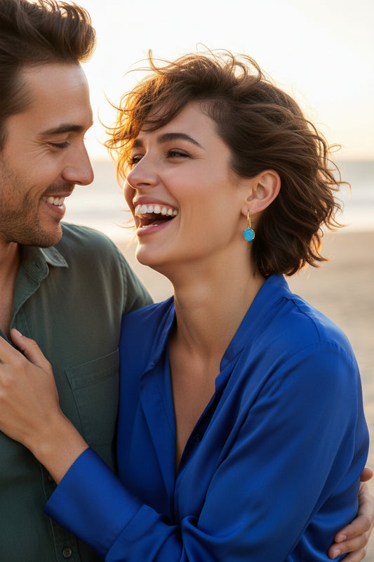 Gold-enhanced sterling silver hook earrings feature luminous blue chalcedony gemstones nestled securely within a beautifully sculpted wave-inspired setting.