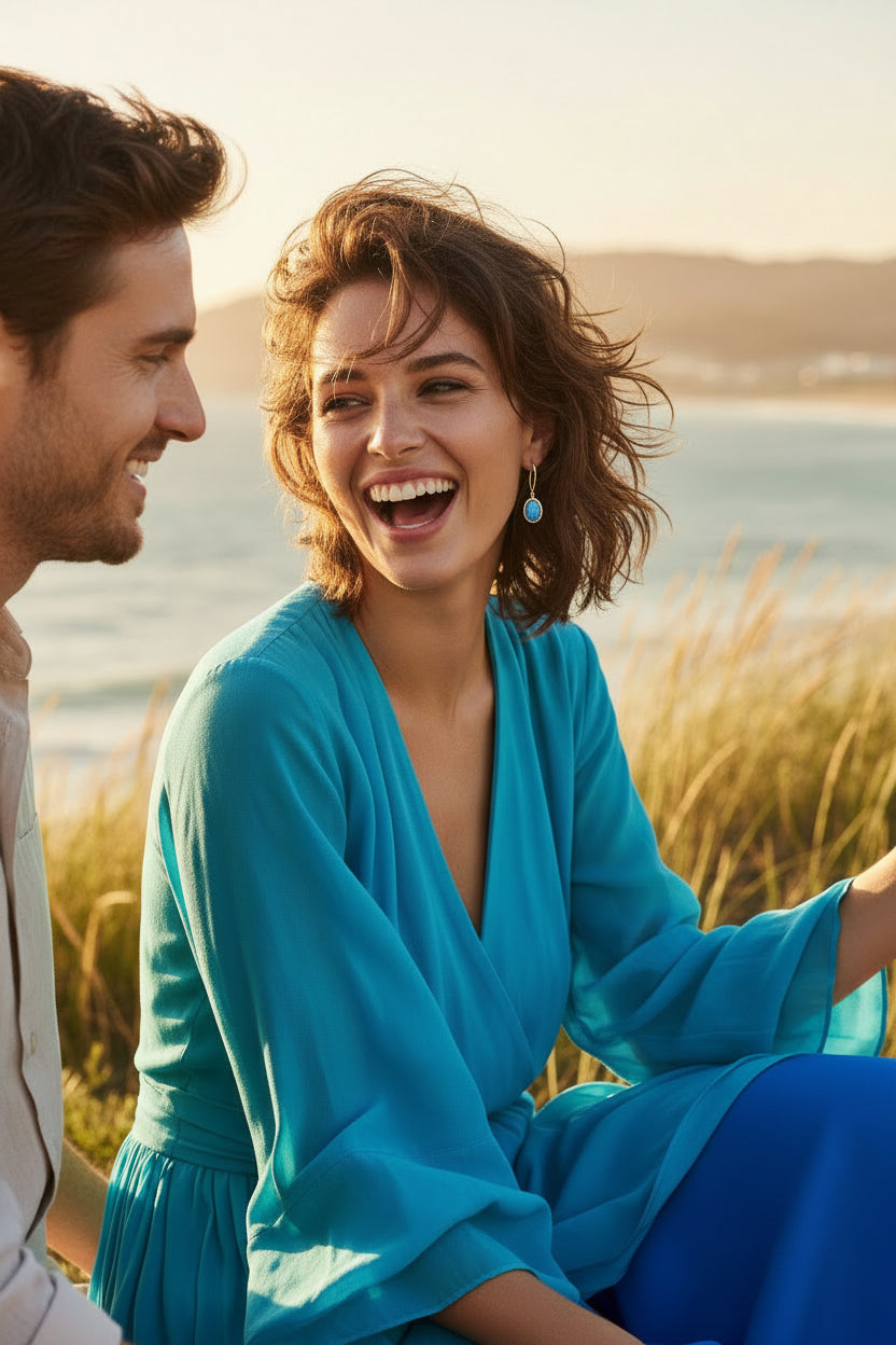 Gold-enhanced sterling silver hook earrings feature luminous blue chalcedony gemstones nestled securely within a beautifully sculpted wave-inspired setting.