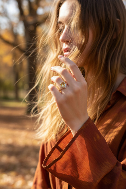 A radiant faceted teardrop citrine ring glows from within a sculptural high-sided sterling silver setting