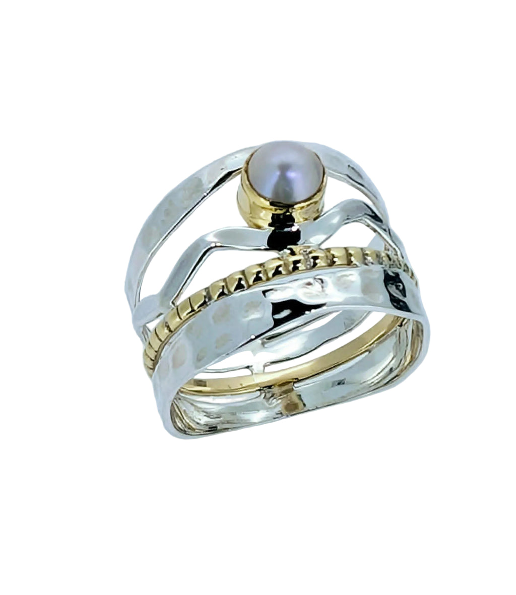 This exquisite ring features a luminous button pearl nestled gracefully at the centre of a woven web of sterling silver and a subtle touch of gold.