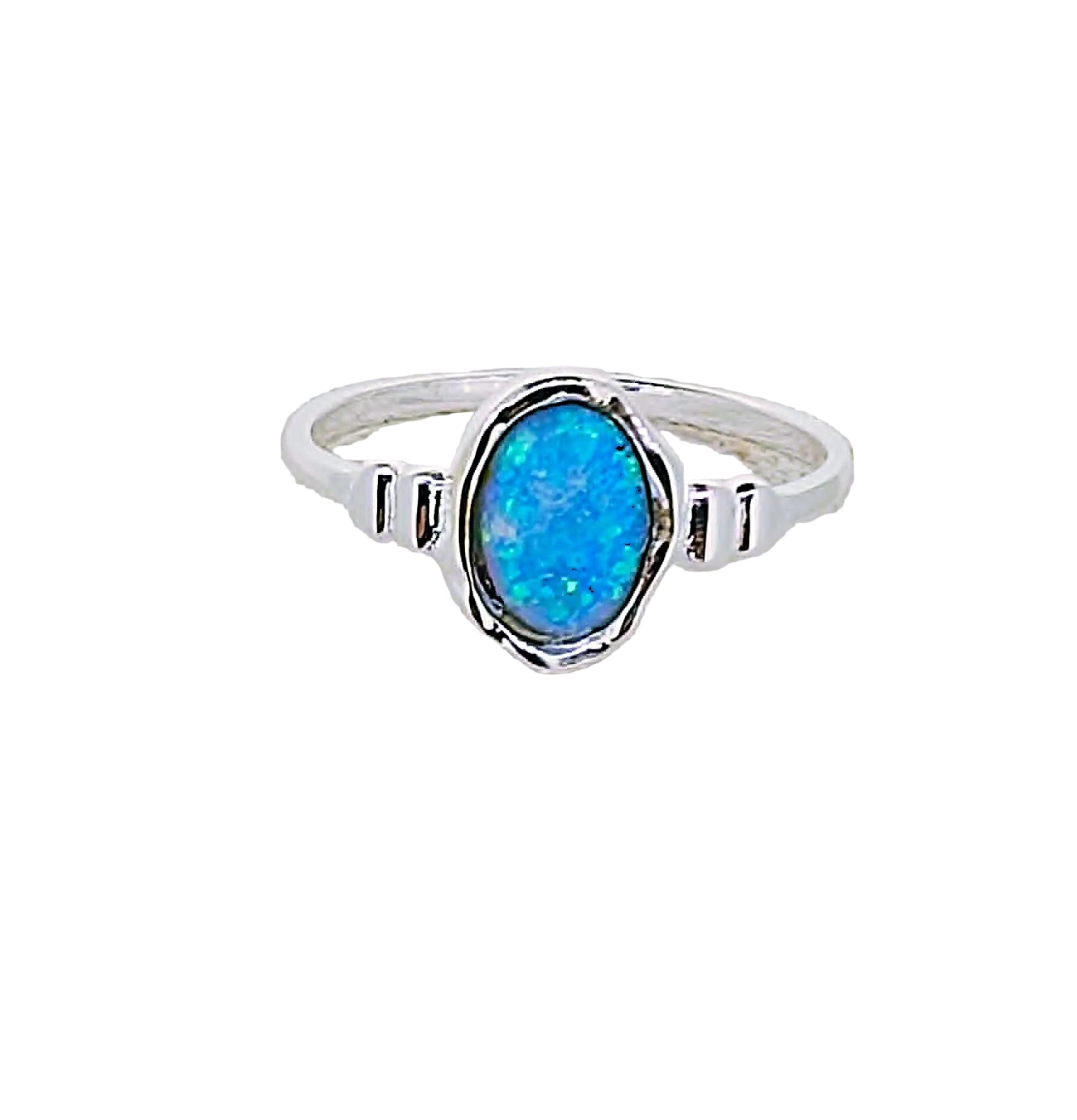 Silver ring with a blue opal stone on a textured white background