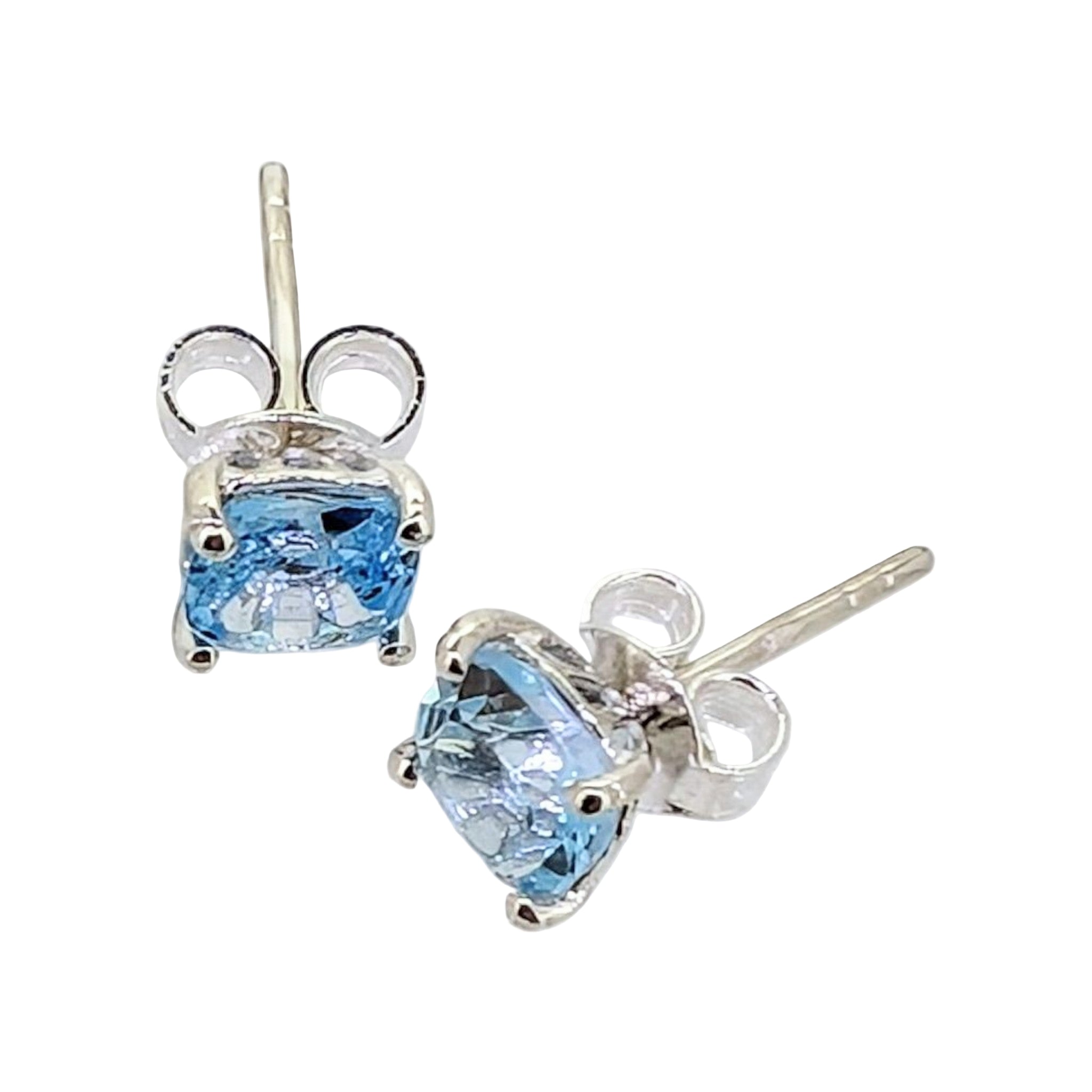 These petite blue topaz sterling silver studs feature a delicate claw setting that securely holds the vibrant gemstones